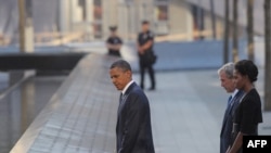 باراک اوباما، رئیس‌جمهوری آمریکا به همراه همسرش، میشل اوباما و جرج بوش، رئیس‌جمهوری پیشین ایالات متحده در محل فروریزی برج شمالی مرکز تجارت جهانی در نیویورک. ۱۱ سپتامبر ۲۰۱۱.