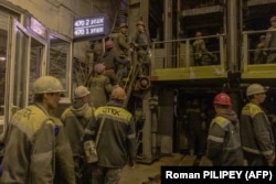 Шахтарі заходять в ліфти, щоб спуститися під землю вугільної шахти в західній частині Донбасу, жовтень 2024 року