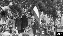 Мешканці Будапешта з угорським прапором на захопленому радянському танку під час придушення угорського повстання. 12 листопада 1956 року