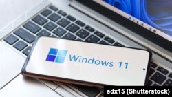 لوگوی ویندوز جدید، و در پس‌زمینه دستگاهی که نسخه آزمایشی ویندوز ۱۱ بر آن نصب شده است