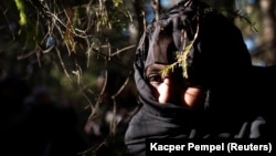 A migrant watches warily after crossing the Belarusian-Polish border in Siemianowka, Poland, on October 25.