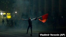 Протестующий машет флагом Кыргызстана во время митинга против результатов парламентских выборов в Бишкеке. Кыргызстан, 5 октября 2020 года.