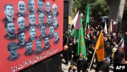 Люди проходять повз плакат із портретами вчених і військових командирів, загиблих під час 12-денної війни між Іраном й Ізраїлем, Тегеран, 5 липня 2025 року