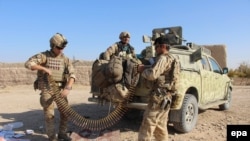 Afghan soldiers sort ammunition during an operation against Taliban militants in the Soor Guder district of Helmand Province late last year.