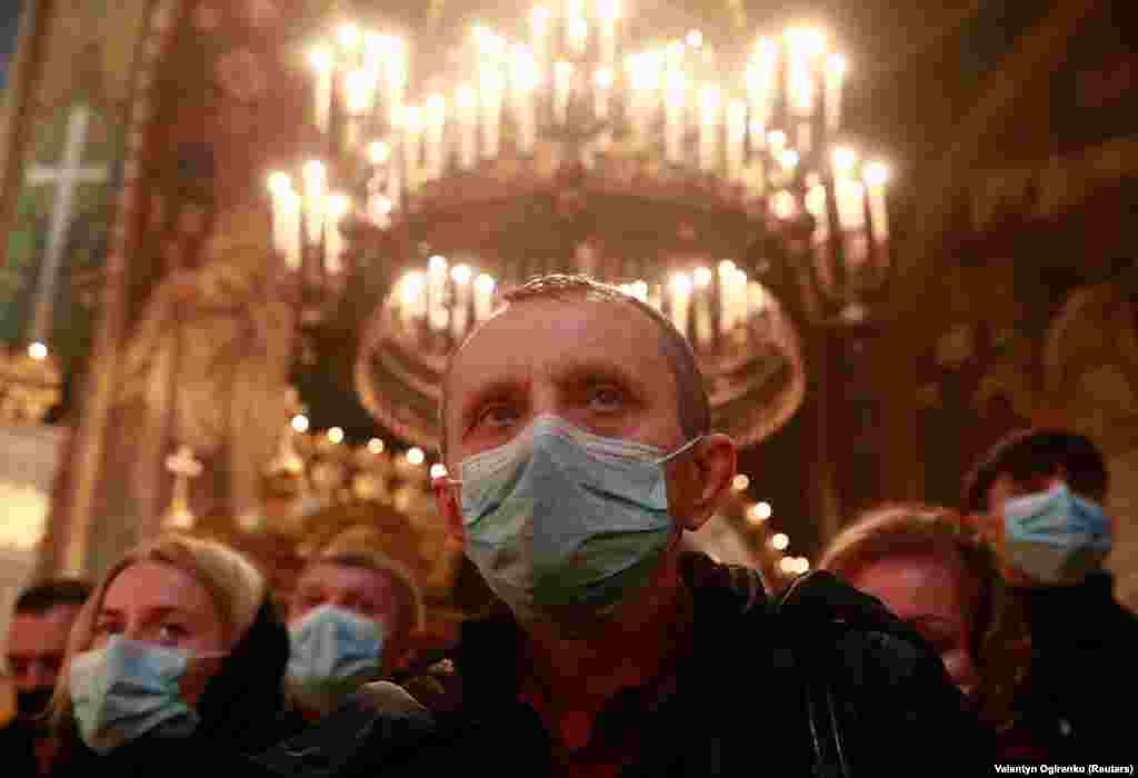 Віряни в масках під час різдвяного богослужіння у Володимирському соборі в Києві
