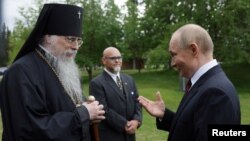 Уладзімір Пуцін (справа) і архіяпіскап Аляксій (зьлева).