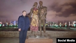Житель Астаны Талгат Шолтаев рядом с композицией "Влюбленные", часть которой - скульптуру девушки - он накрыл платком. Март 2016 года.