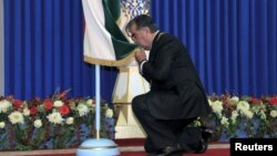 Президент Имомали Раҳмон 2013 йилдаги сайловдан кейин Душанбедаги инаугурация маросимида давлат байроғини ўпмоқда. 