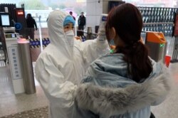 امدادگری در ایستگاه شاننیگ در حال آزمایش یکی از مسافران است