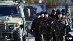 Ukraine -- Ukrainian army soldiers walk outside the Ukrainian military base blocked by Russian forces in Perevalnoye, near Simferopol, March 17, 2014