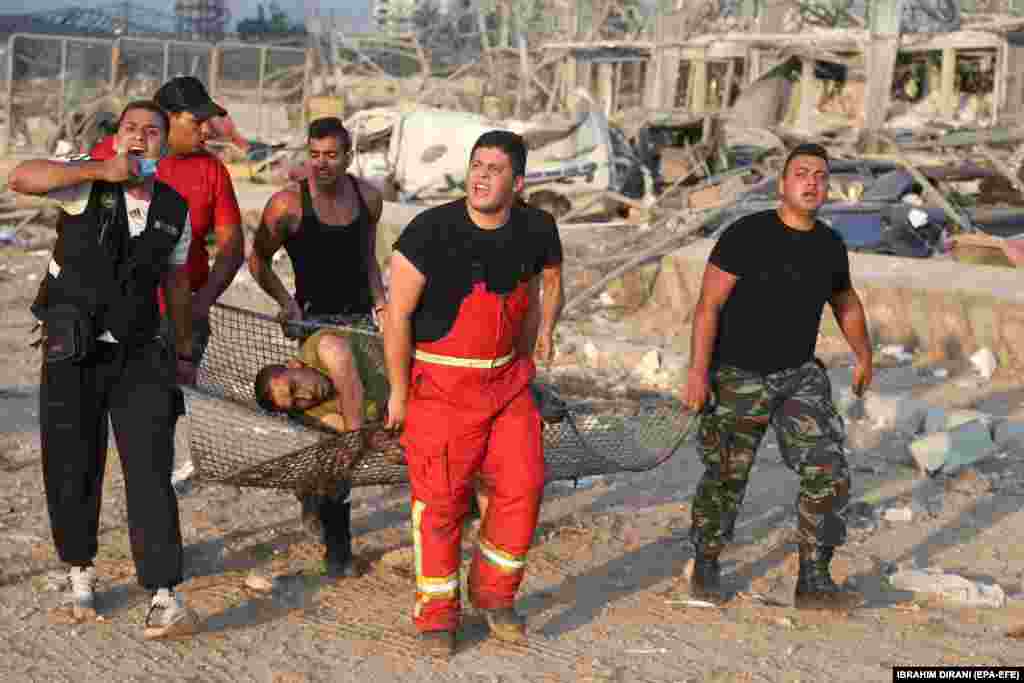 На фото від 4 серпня: пораненого чоловіка евакуюють з місця вибуху.&nbsp; За словами&nbsp;директора ліванського Червоного Хреста Джорджа Кеттанеха,&nbsp;Червоний Хрест координує дії з Міністерством охорони здоров&rsquo;я, щоб морги приймали жертв, оскільки лікарні переповнені.&nbsp;Ліванське Міністерство охорони здоров&rsquo;я раніше&nbsp;заявляло про 73 загиблих&nbsp;і понад чотири тисячі поранених внаслідок вибуху, що стався в районі порту. Сьогодні у Червоному Хресті повідомили, що кількість загиблих&nbsp;зросла до 100​