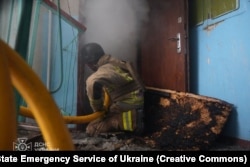 Спасатели тушат огонь в одной из квартир многоквартирного жилого дома в Сумах, куда попала российская ракета. 24 марта 2025 года