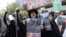 People attend an anti-Israeli protest in Tehran carrying portraits of generals and nuclear scientists killed in the Israeli strikes on Iran on June 13, 2025.