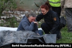 Женщина у тела погибшего родственника в Святошинском районе Киева, 24 апреля 2025 года