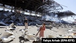 Дівчинка й повстанець Хуті в Ємені на місці, куди влучила ракета, ймовірно, випущена силами коаліції на чолі з Саудівською Аравією