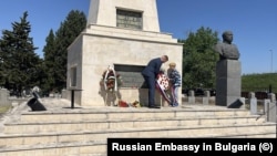 Дете с военно кепе поднася венец на паметник на загинали съветски войници във Видин.