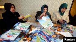 Supporters of the Islamic Renaissance Party of Tajikistan sort leaflets in Dushanbe in February 2015. For the first time in 20 years, the party will not be participating in parliamentary elections being held on March 1.