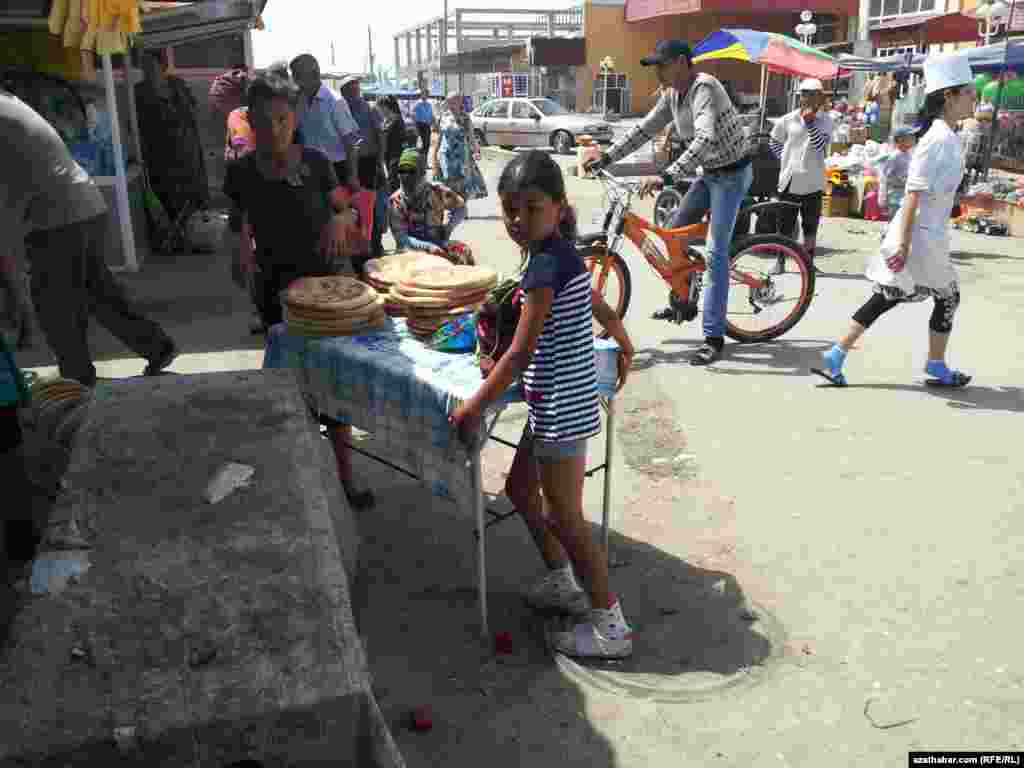 Türkmenabadyň bazarynda çörek satýan gyzjagazlar.