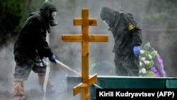 Похороны человека, умершего от COVID-19, на одном из кладбищ на окраине Москвы. 15 мая 2020 года