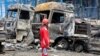 A rescue worker stands in front of burned vehicles after a massive explosion and fire rocked the Shahid Rajaei port near the southern port city of Bandar Abbas, Iran, on April 26