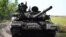 Ukrainian soldiers drive a T-72 tank on the front line in eastern Ukraine.