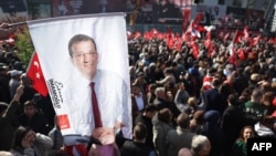 Опозиционни привърженици държат транспарант с лика на Екрем Имамоглу по време на антиправителствен протест в Истанбул, 6 април 2025 г.