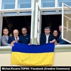 Опозиційні депутати вивішують прапор України з вікна будівлі парламенту Чехії, Прага, 7 листопада 2025 року