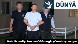 Gürjüstanyň howpsuzlyk gulluklary Georgiý Baçiýaşwilini eli gandally äkidip barýarlar.