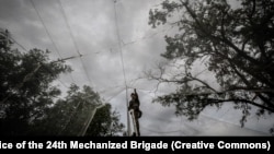 Українські військові встановлюють антидронові сітки на одній з доріг у Донецькій області. Жовтень 2025 року