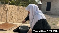 Ҳовлидаги қудуқдан сув олаётган онахон. Хатлон вилояти.