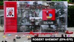 Дитяче взуття та символічні сліди крові біля стенду в рамках акції протесту проти вторгнення Росії до України під будівлею російського посольства в Румунії. Бухарест, 29 квітня 2022 року