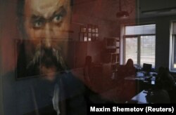 Відображення на склі дітей і вчителя в класі з портретом Тараса Шевченка в українській школі-гімназії в Сімферополі, 10 квітня 2014 року. Цього дня представники російської окупаційної влади змусили директора школи Наталію Руденко написати заяву про звільнення