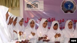 گروهی از دختران افغان که در رشته مامامایی فارغ‌التحصیل شده‌اند در مراسمی سوگند حرفه‌ای یاد می‌کنند