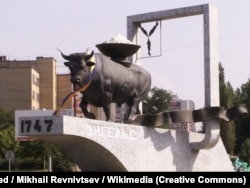 Жовтий Клин. Пам'ятник гербу Енгельського муніципального району. Місто Енгельс Саратовської області, колишня назва – Покровськ, до того це була Покровська слобода, яку заснували українські чумаками у 1747 році. Поволзькі німці називали місто Kosakenstadt