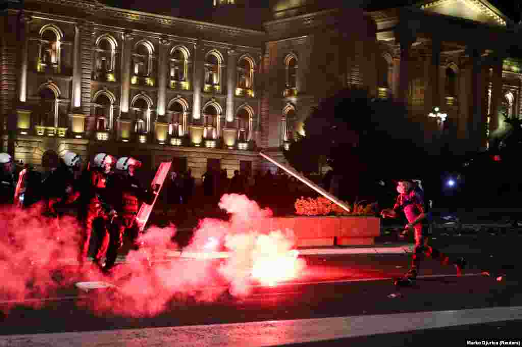 На фото: активіст біжить на поліцейських та жбурляє у них брус. Крім наявності затриманих та постраждалих (з обох боків) також були підпалені 5 поліцейських автівок