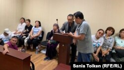 Активист Ербол Есхожин (в центре) и его адвокат Толеген Шаиков в зале административного суда. Нур-Султан, 25 августа 2019 года. 
