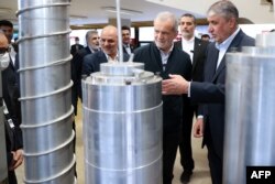 Predsednik Irana Masud Pezeškijan (drugi desno) i šef iranske Organizacije za atomsku energiju Mohamed Eslami (desno) tokom Nacionalnog dana nuklearne tehnologije u Teheranu 9. aprila