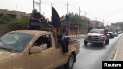 İŞİD yaraqlıları Mosulda İraq ordusundan qənimət qalan maşınlarda. 12 iyun 2014