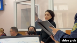 "Бұрынғы күйеуін өлтіру үшін киллер жалдаған" деген айып тағылған Эльвира Еркебаева (оң жақта тұрған) мен онымен бірге сотталып жатқан Максим Кузнецовтың соты (видеодан скриншот)