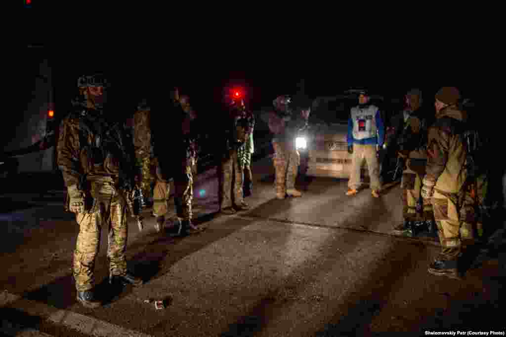 Представник групи спостерігачів від ОБСЄ стоїть посередині між українськими військовими і бойовиками