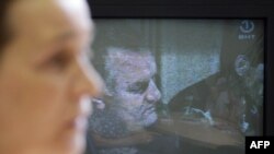 تصویر راتکو ملادیچ بر صفحه تلویزیونی در بوسنی و هرزه گوین که این فرمانده صرب متهم به انجام نسل کشی در این کشور است.