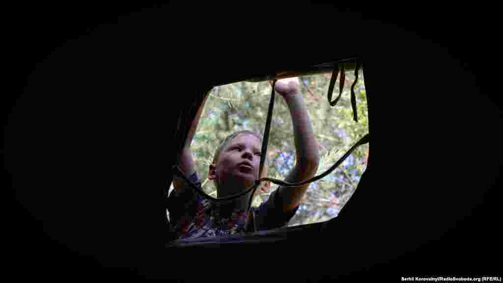 Хлопчик лагодить намет