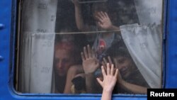 Рідні прощаються один з одним біля евакуаційного поїзда на залізничному вокзалі в Покровську, Донецька область, Україна, 30 серпня 2024 року