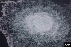 Această fotografie difuzată la 28 septembrie 2022 de pe o aeronavă a Gărzii de Coastă suedeze (Kustbevakningen) arată degajarea gazului emanat de o scurgere pe gazoductul Nord Stream 1, în zona economică suedeză din Marea Baltică.
