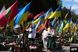Сям’я моліцца перад магілай загінулага ўкраінскага салдата на Лычакаўскіх вайсковых могілках у Вялікдзень у Львове, 20 красавіка 2025 году