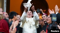 Папа Франциск выпускает голубя как символ мира на встрече с представителями ассиро-халдейской католической общины в Тбилиси в сентябре 2016 года
