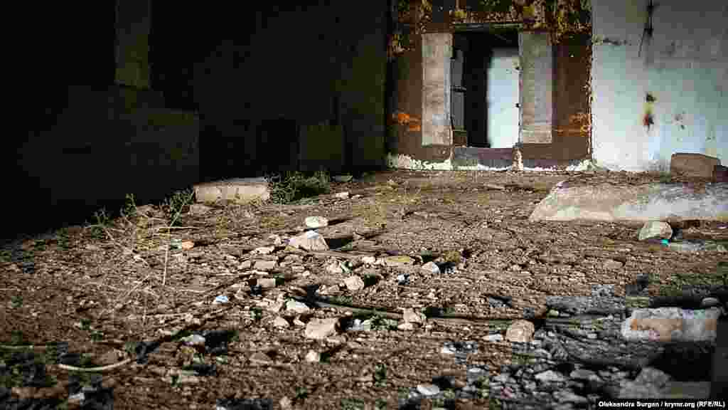 Tabanda beton bloklarınıñ parçaları, qurulış çöplügi ve aştan qalğan sarğılıqlar yata. Yerli sakinler, yaşlar mında diskoteka yapqanını ayta