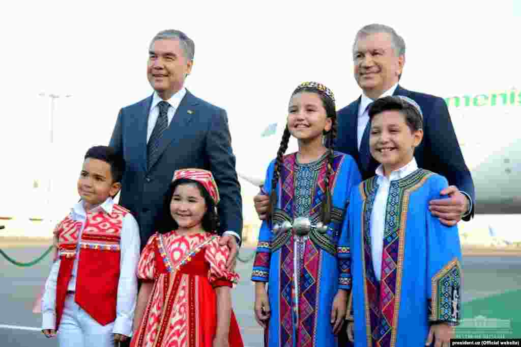 Özbek we türkmen prezidentleri Daşkendiň aeroportynda milli lybasdaky çagalar bilen surata düşýärler.