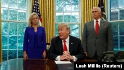 Президент Дональд Трамп Ак үйдө буйрукка кол койгону жаткан учур. 20-июнь, 2018-жыл.