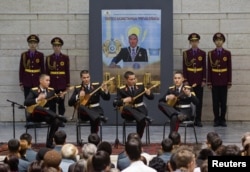 Кадеты играют на домбре на фоне портрета Нурсултана Назарбаева в Центральном государственном музее. Алматы, 28 ноября 2012 года